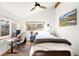 Bright bedroom with a desk, a view of the lush yard, and a ceiling fan at 10180 Blue Sky Trl, Conifer, CO 80433