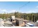 Outdoor deck featuring comfortable seating, a modern fire pit, and scenic mountain views at 10180 Blue Sky Trl, Conifer, CO 80433