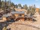 Charming wood home with a spacious deck overlooking a scenic hillside with many trees and blue skies at 10180 Blue Sky Trl, Conifer, CO 80433