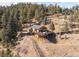 A wood home nestled on a hill, complete with a spacious deck, offering stunning views of the surrounding landscape at 10180 Blue Sky Trl, Conifer, CO 80433