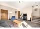 Cozy living room with stairs, a wooden coffee table, and natural lighting at 10180 Blue Sky Trl, Conifer, CO 80433