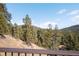 Scenic mountain view with lush evergreens from a home's outdoor deck at 10180 Blue Sky Trl, Conifer, CO 80433