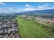 Stunning aerial perspective of homes in a community adjacent to open land with a vast mountain range in the distance at 10614 Kicking Horse Dr, Littleton, CO 80125