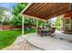 Inviting backyard patio with a pergola, dining set, and lush green lawn at 10614 Kicking Horse Dr, Littleton, CO 80125