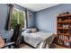 Calm bedroom with blue walls, a window, and a bookshelf with books and toys at 10614 Kicking Horse Dr, Littleton, CO 80125
