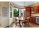 Bright breakfast nook features a round wood table with four chairs and windows overlooking the backyard at 10614 Kicking Horse Dr, Littleton, CO 80125
