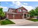 Attractive two-story home features a three-car garage, a welcoming porch, and a well-kept lawn at 10614 Kicking Horse Dr, Littleton, CO 80125