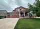 Charming two-story house with a well-maintained lawn, inviting porch, and American flag at 10614 Kicking Horse Dr, Littleton, CO 80125