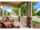 Inviting covered front porch features wood chairs and stone pillars, offering a relaxing outdoor space at 10614 Kicking Horse Dr, Littleton, CO 80125