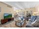 Bright living room featuring beamed ceilings, neutral paint, and hardwood floors with grey sofa and access to deck at 130 N Pearl St # 304, Denver, CO 80203