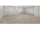 A spacious unfinished basement with carpeted flooring and two windows providing natural light at 23421 E Long Pl, Aurora, CO 80016