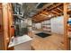 Unfinished basement with exposed ceiling, and a utility sink with nearby shelving at 23421 E Long Pl, Aurora, CO 80016