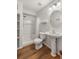 This well-lit bathroom has wood-look flooring, pedestal sink, and a shower with white tiling at 23421 E Long Pl, Aurora, CO 80016