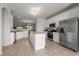 Spacious kitchen with white cabinets, stainless steel appliances, and an island overlooking the living area at 23421 E Long Pl, Aurora, CO 80016