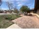 Backyard patio area with stone pavers, partial side view of home, trees, and lawn at 5600 Dover St, Arvada, CO 80002