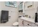 Cozy bathroom with a modern vanity, a toilet, and a frosted window providing natural light and privacy at 5600 Dover St, Arvada, CO 80002