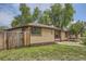 Well-maintained home featuring a brick exterior, a wooden fence, and lush green lawn, providing a cozy and private setting at 5600 Dover St, Arvada, CO 80002