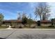 Charming single-story home featuring a brick exterior, mature trees, and a well-maintained front yard at 5600 Dover St, Arvada, CO 80002