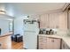 Well-lit kitchen with ample cabinet space, white appliances, and a cozy dining area for convenient meal preparation at 5600 Dover St, Arvada, CO 80002
