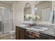 Bathroom with granite counter tops, double sinks, stylish mirrors, and walk in shower at 1078 Oak Cir, Denver, CO 80215