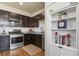 Well-lit kitchen features stainless steel appliances, dark cabinets, and a stylish tile backsplash at 1078 Oak Cir, Denver, CO 80215