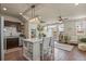 Open-concept living space with kitchen island, stainless appliances, and hardwood floors at 1078 Oak Cir, Denver, CO 80215