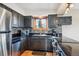 Well-lit kitchen featuring stainless steel appliances, gray cabinets, and a mosaic tile backsplash at 11564 Green Ct, Conifer, CO 80433