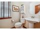 Clean and bright bathroom with pedestal sink and a white toilet at 5723 S Union Ct, Littleton, CO 80127