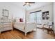Cozy bedroom features a queen bed, wood floors, ceiling fan and natural light at 5723 S Union Ct, Littleton, CO 80127