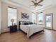 Bright main bedroom features a tray ceiling, ceiling fan, wood floors and walk out access at 5723 S Union Ct, Littleton, CO 80127