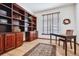 Home office with built-in wooden shelving and hardwood floors at 5723 S Union Ct, Littleton, CO 80127