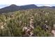 Aerial view of a wooded property with lush pine trees and mountain views in the background at 27711 Moffat Rd, Evergreen, CO 80439