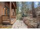 Landscaped yard with a stone pathway and mature trees create a serene outdoor space at 27711 Moffat Rd, Evergreen, CO 80439