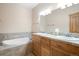 A spacious bathroom boasts dual vanities, a large soaking tub, and designer tile flooring at 27711 Moffat Rd, Evergreen, CO 80439