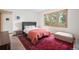 A carpeted bedroom featuring a gray bed, vibrant rug, and serene natural light from large windows at 27711 Moffat Rd, Evergreen, CO 80439