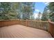 Wooden deck with views of the surrounding pine trees at 27711 Moffat Rd, Evergreen, CO 80439
