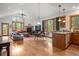 Open-concept living room featuring hardwood floors, stone fireplace, and large windows with wooded views at 27711 Moffat Rd, Evergreen, CO 80439