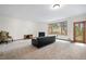 A spacious living room with large windows, a cozy fireplace, and neutral carpeting at 27711 Moffat Rd, Evergreen, CO 80439