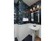 Charming powder room with bold wallpaper, wainscoting, and a pedestal sink at 810 Trail Ridge Dr, Louisville, CO 80027