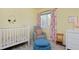 Bright Bedroom with a crib, chair, and floral-patterned curtains at 810 Trail Ridge Dr, Louisville, CO 80027