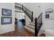 Entryway featuring hardwood floors, a staircase with black railings, and views of the living room at 810 Trail Ridge Dr, Louisville, CO 80027