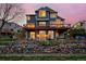 Backyard with stone wall, garden beds, mature trees, and a spacious deck with comfortable seating. Large windows at 810 Trail Ridge Dr, Louisville, CO 80027