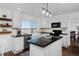 Well-lit kitchen featuring an island with black countertops and white cabinetry at 810 Trail Ridge Dr, Louisville, CO 80027