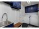 Laundry room with blue cabinets, sink, and washer and dryer at 810 Trail Ridge Dr, Louisville, CO 80027