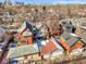 An aerial view of a neighborhood with colorful houses, garages, and the Denver skyline in the background in winter at 2336 N High St, Denver, CO 80205