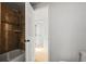 Bathroom showcasing a shower-tub combo with tiled walls, adjacent to an open doorway to another room at 2336 N High St, Denver, CO 80205