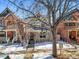 The exterior of a two-story home is showcased with a swing hanging from a tree in the front yard during winter at 2336 N High St, Denver, CO 80205