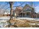 Neighborhood view showing colorful home with a front porch surrounded by a tree and snow on the lawn at 2336 N High St, Denver, CO 80205