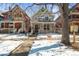 The exterior of a two-story home is showcased with a swing hanging from a tree in the front yard during winter at 2336 N High St, Denver, CO 80205