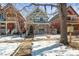 The exterior of a two-story home is showcased with a swing hanging from a tree in the front yard during winter at 2336 N High St, Denver, CO 80205